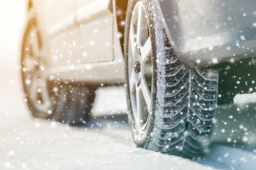 close up of car wheels rubber tires in deep winter snow transportation and safety concept