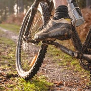 close up of caucasian man's muddy foot on mountain bike