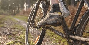 close up of caucasian man's muddy foot on mountain bike