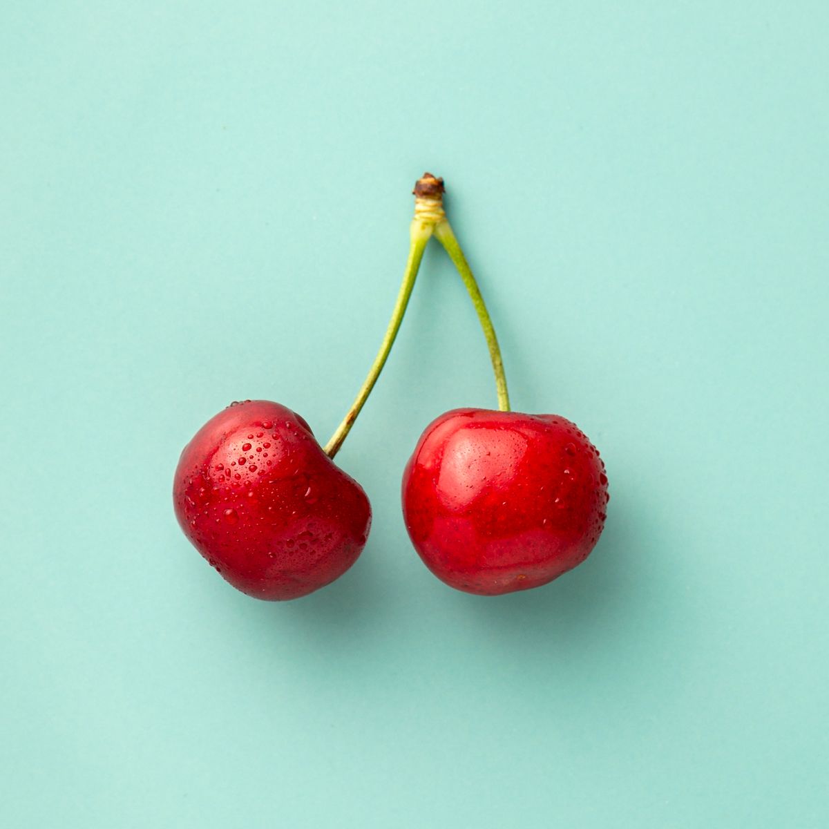 close up of cherries against turquoise background