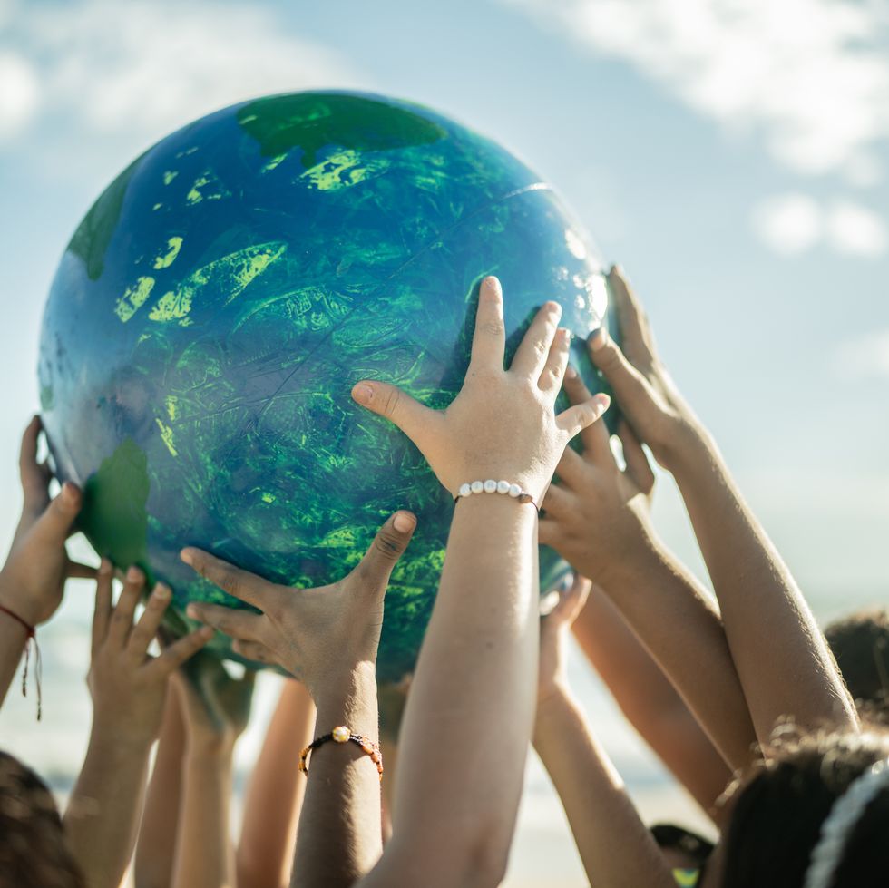 close up of children holding a planet at the beach