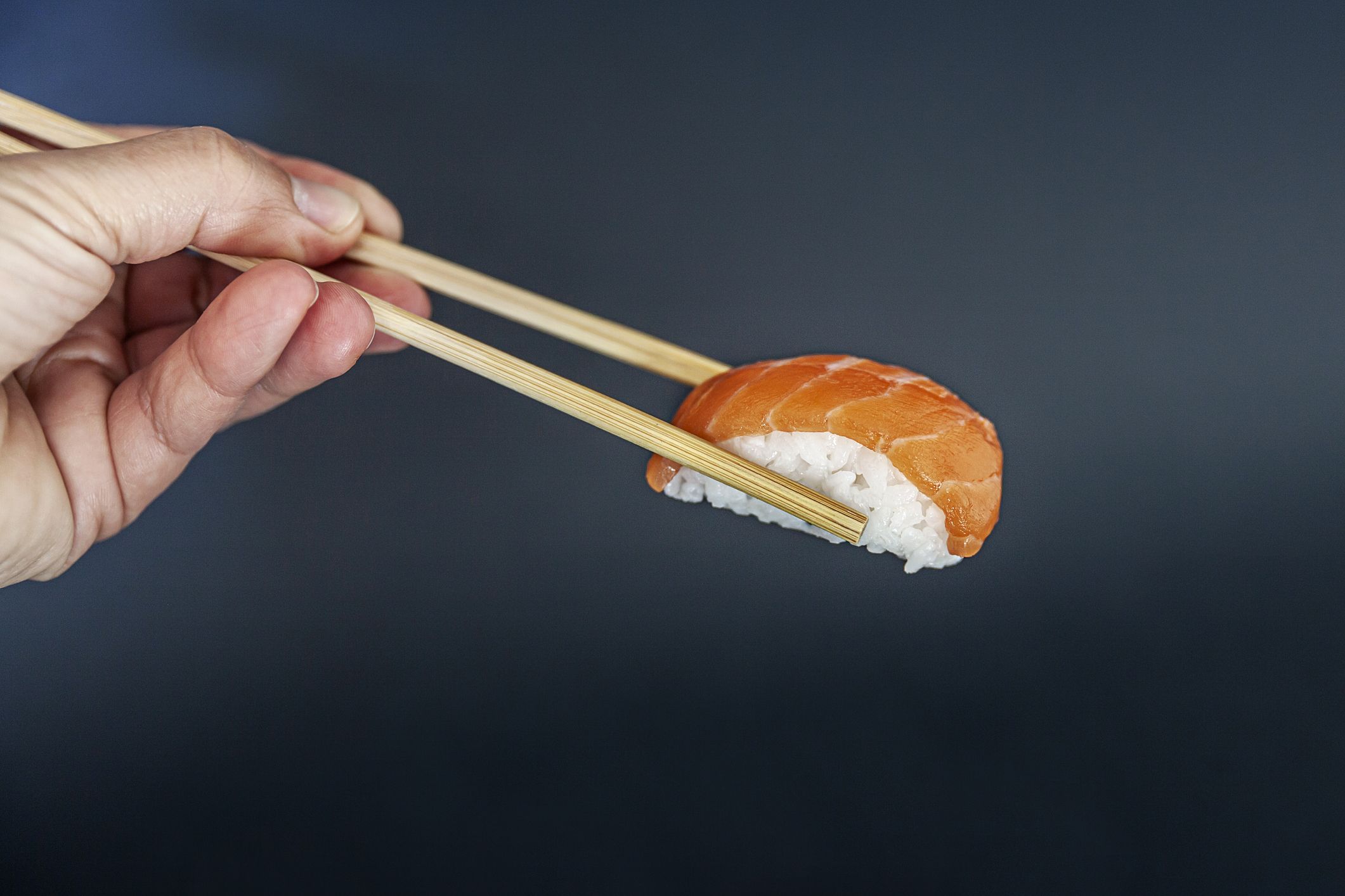 https://hips.hearstapps.com/hmg-prod/images/close-up-of-chopsticks-holding-sushi-royalty-free-image-1653994762.jpg