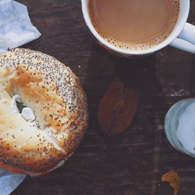 Close-Up Of Coffee Cup and poppyseed bagel