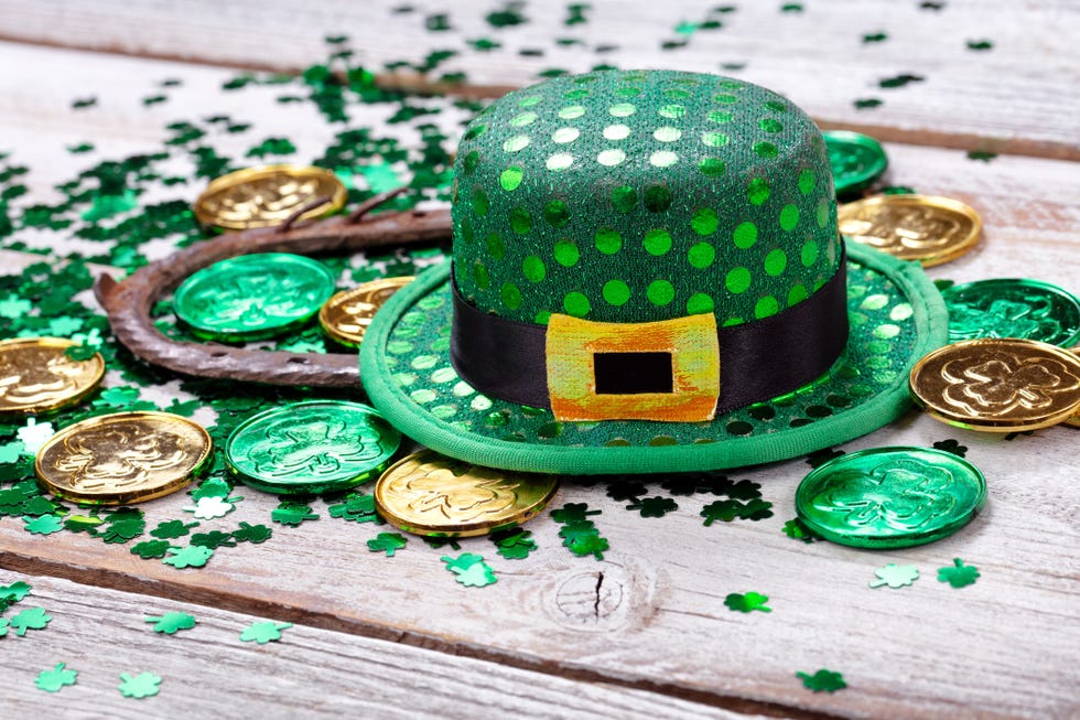 close up of coins with horseshoe and hat on wooden table