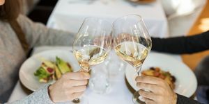 close up of couple clinking wine glasses in a restaurant