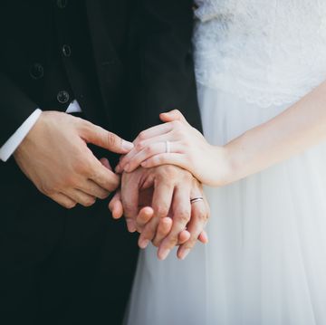 close up of wedded couple holding hands