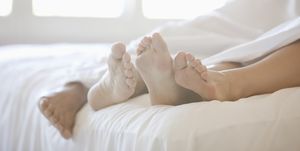 Close up of couple's feet in bed
