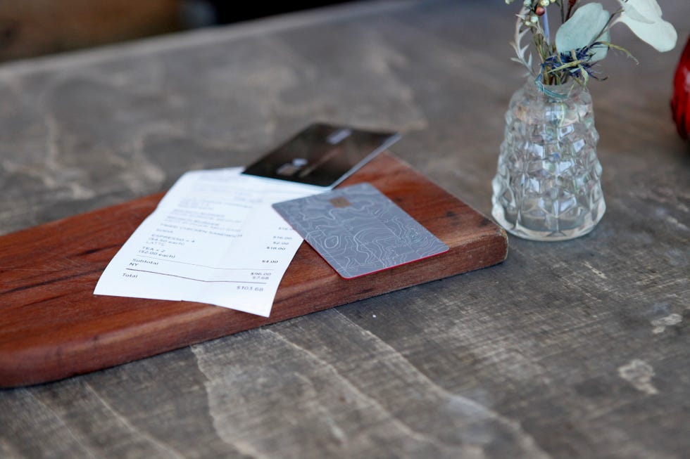 close up of credit cards and bill on table in rustic restaurant