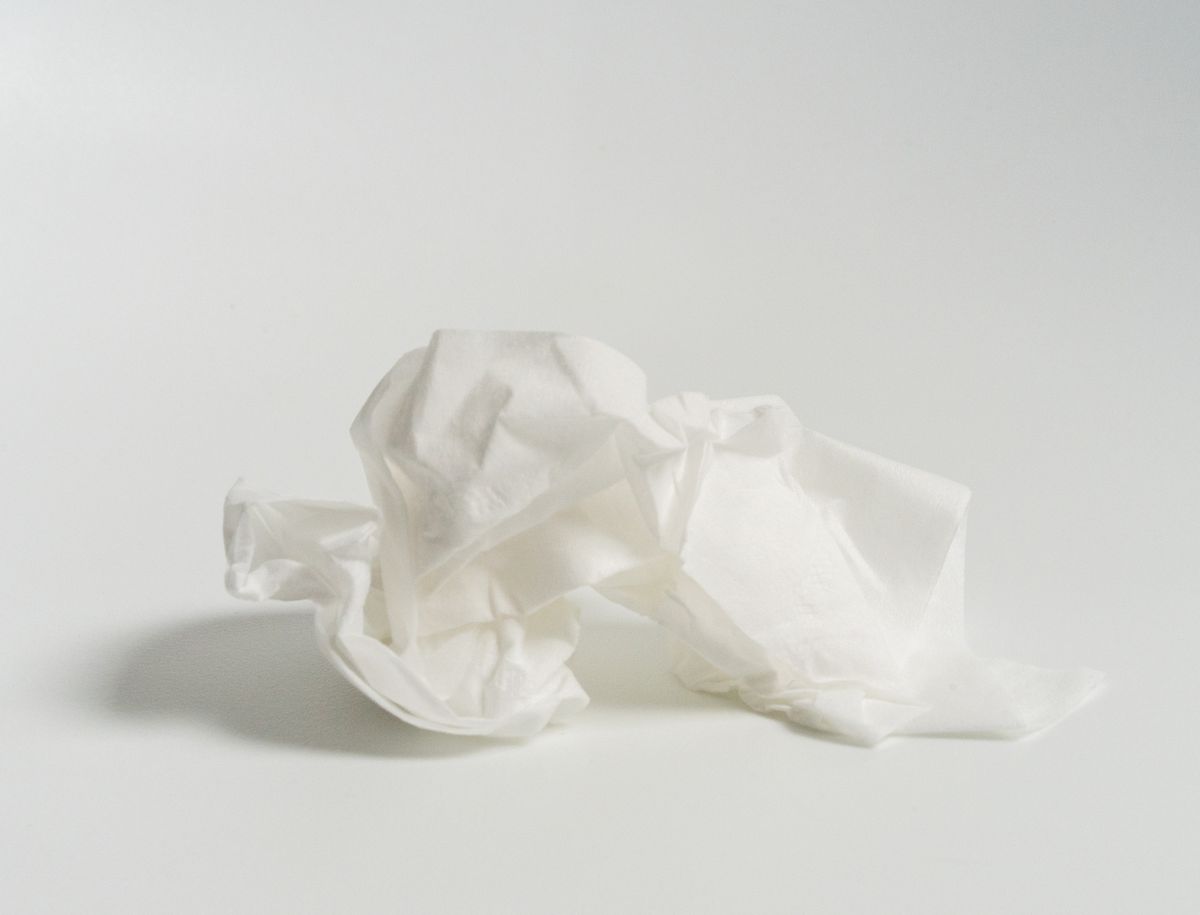 cold vs sinus infection  closeup of crumpled tissue against white background