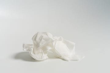 omicron symptoms, closeup of crumpled tissue against white background