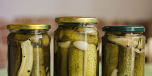 close up of cucumbers in glass jar on table