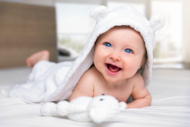 close up of cute baby smiling while lying on bed