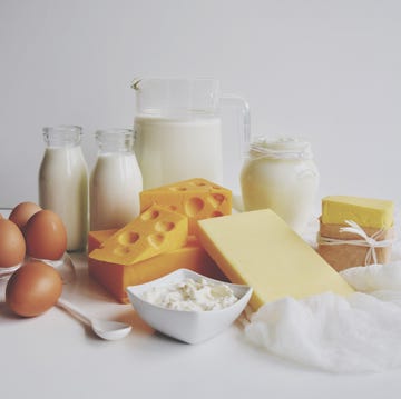 close up of dairy products on table against white background