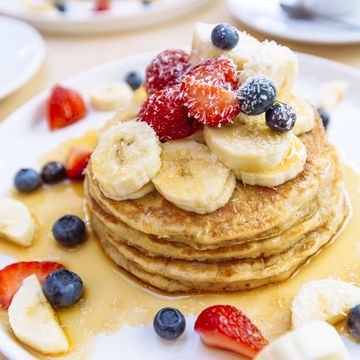 close up of delicious pancakes with fresh fruits berries and maple syrup on a plate
