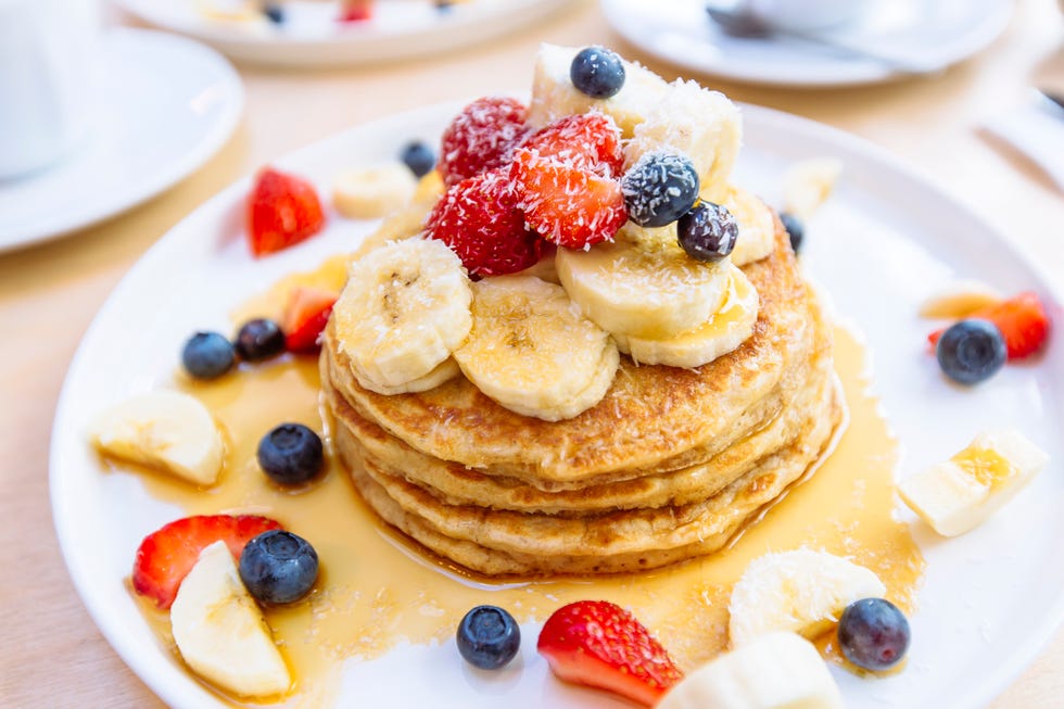 closeup of delicious pancakes with fresh fruits berries and maple syrup on a plate