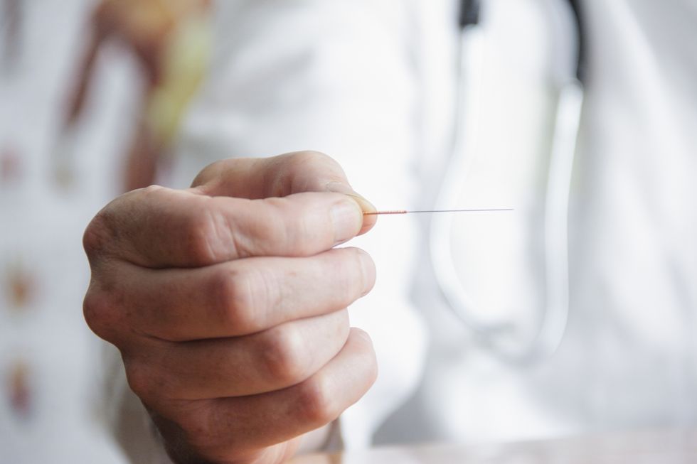 close up of doctor holding needle