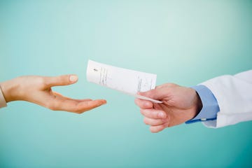 close up of doctor's hand giving prescription to patient, studio shot