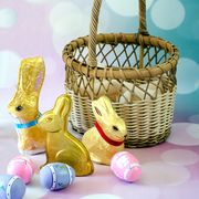close up of easter bunnies with eggs and wicker basket against abstract backgrounds