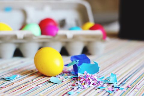 close up of easter egg with confetti on table