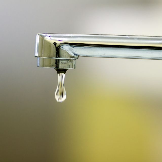 close up of faucet with turned drop water in modern bathroom horizontal crop with shallow depth of field