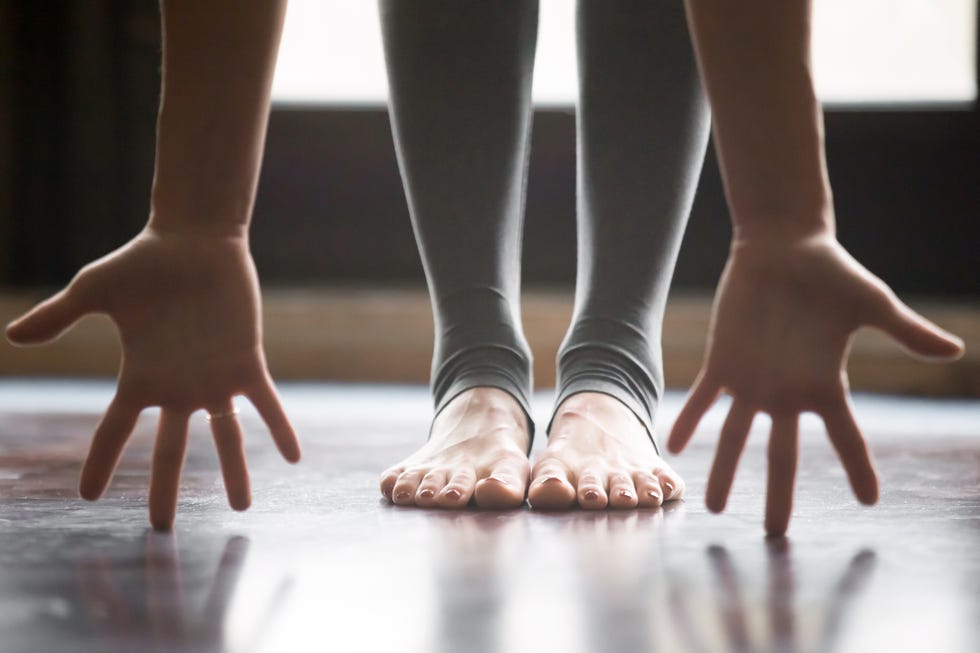 Close up of female in uttanasana pose, legs yoga pants