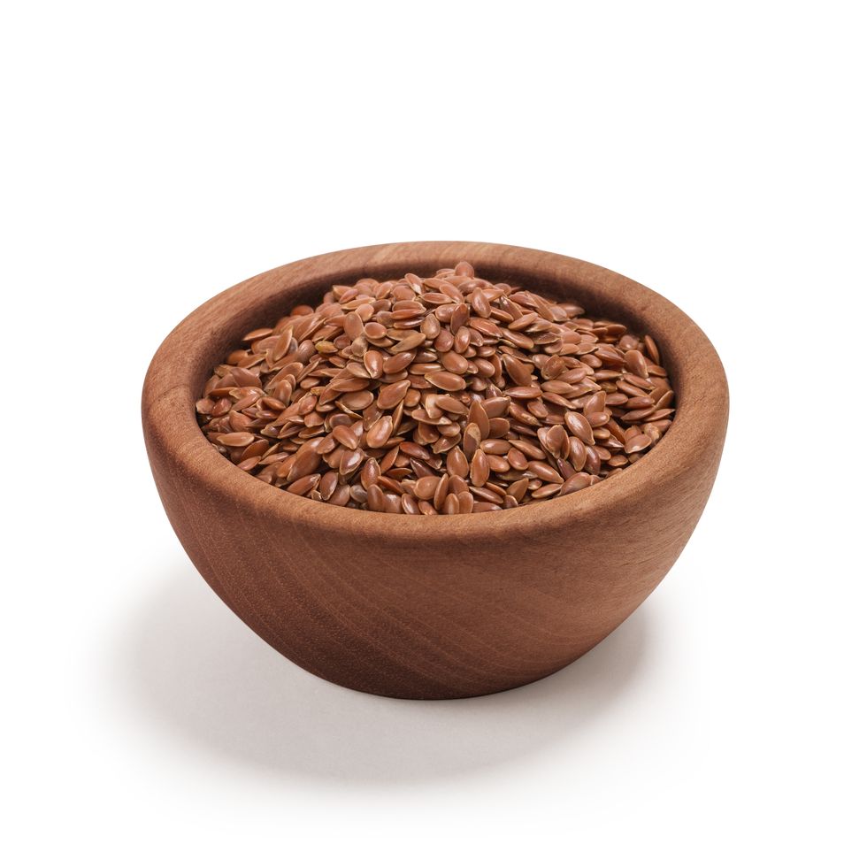 close up of flax seeds in bowl against white background