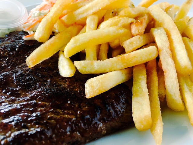 Close-Up Of French Fries And Steak