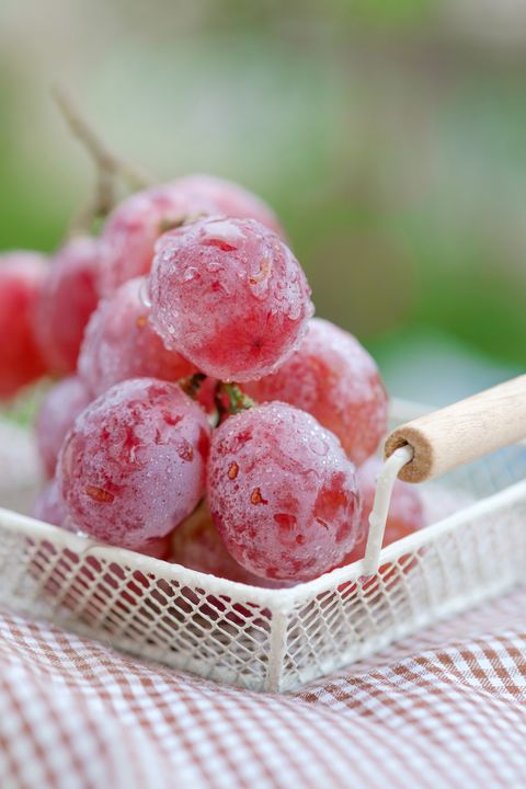 Close-Up Of Frozen Red Grapes In Basket On Table