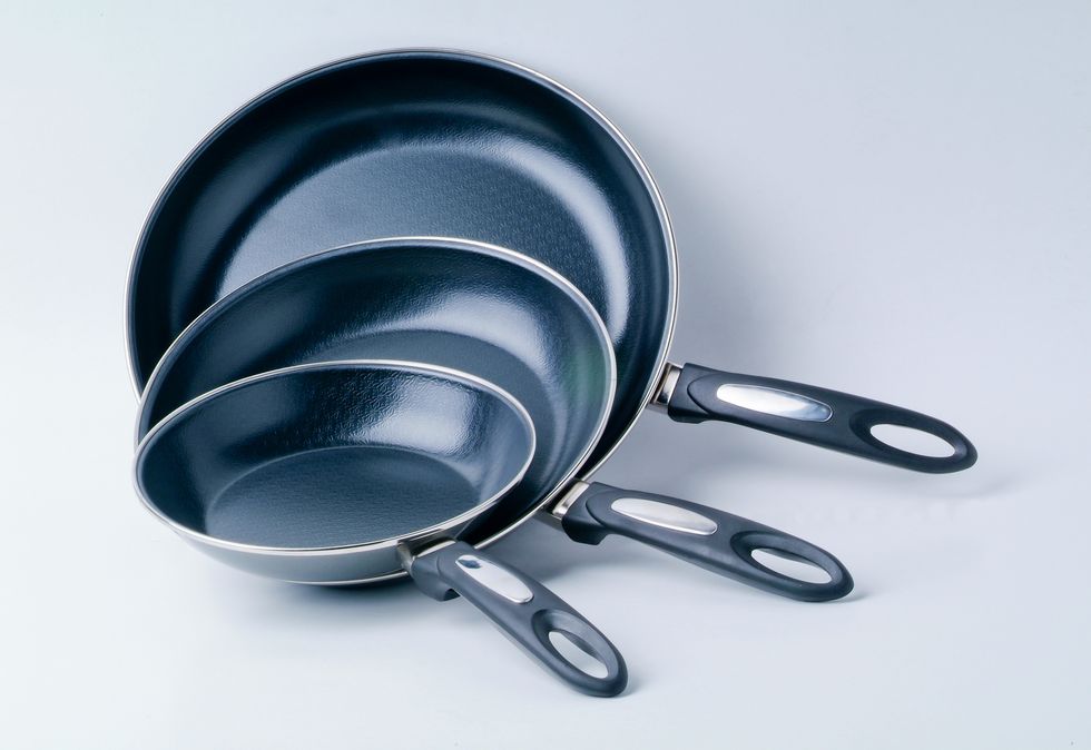 closeup of frying pans against white background