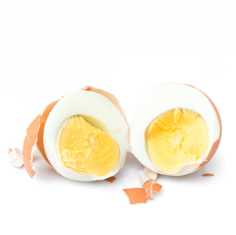 Close-Up Of Halved Boiled Egg Over White Background Close-Up Of Halved Boiled Egg Over White Background