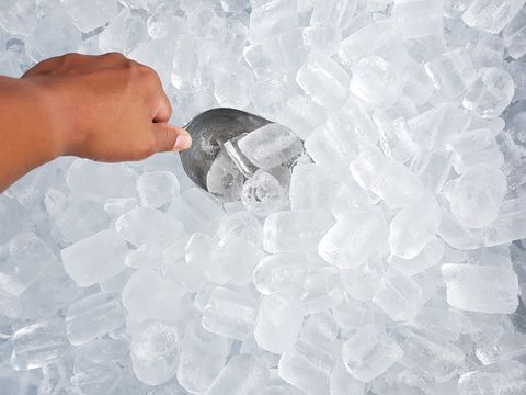 Close-Up Of Hand Scooping Ice Cubes