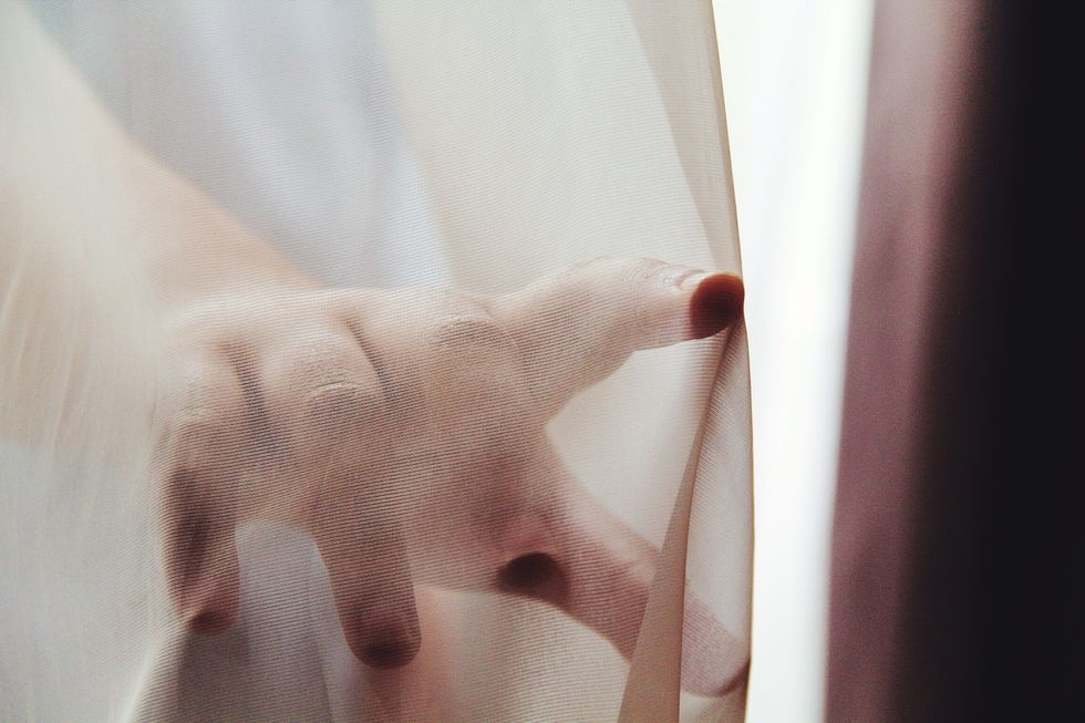 close up of hand touching curtain