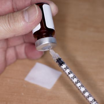 close up of handheld needle and syringe with testosterone vial