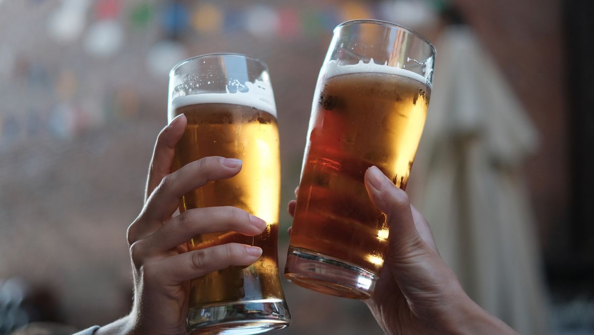 Close-Up Of Hands Holding Beer Glasses