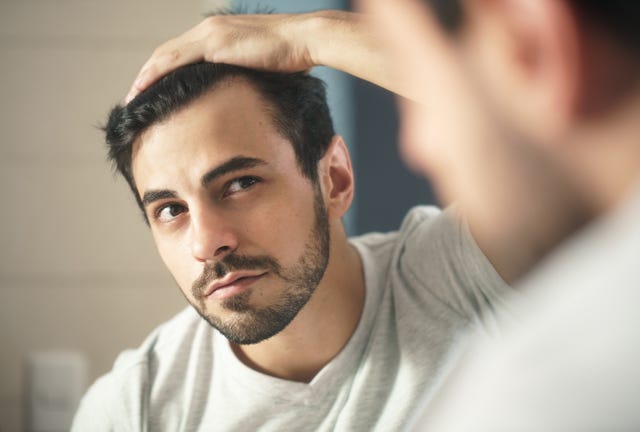 close up of handsome man looking in mirror at home