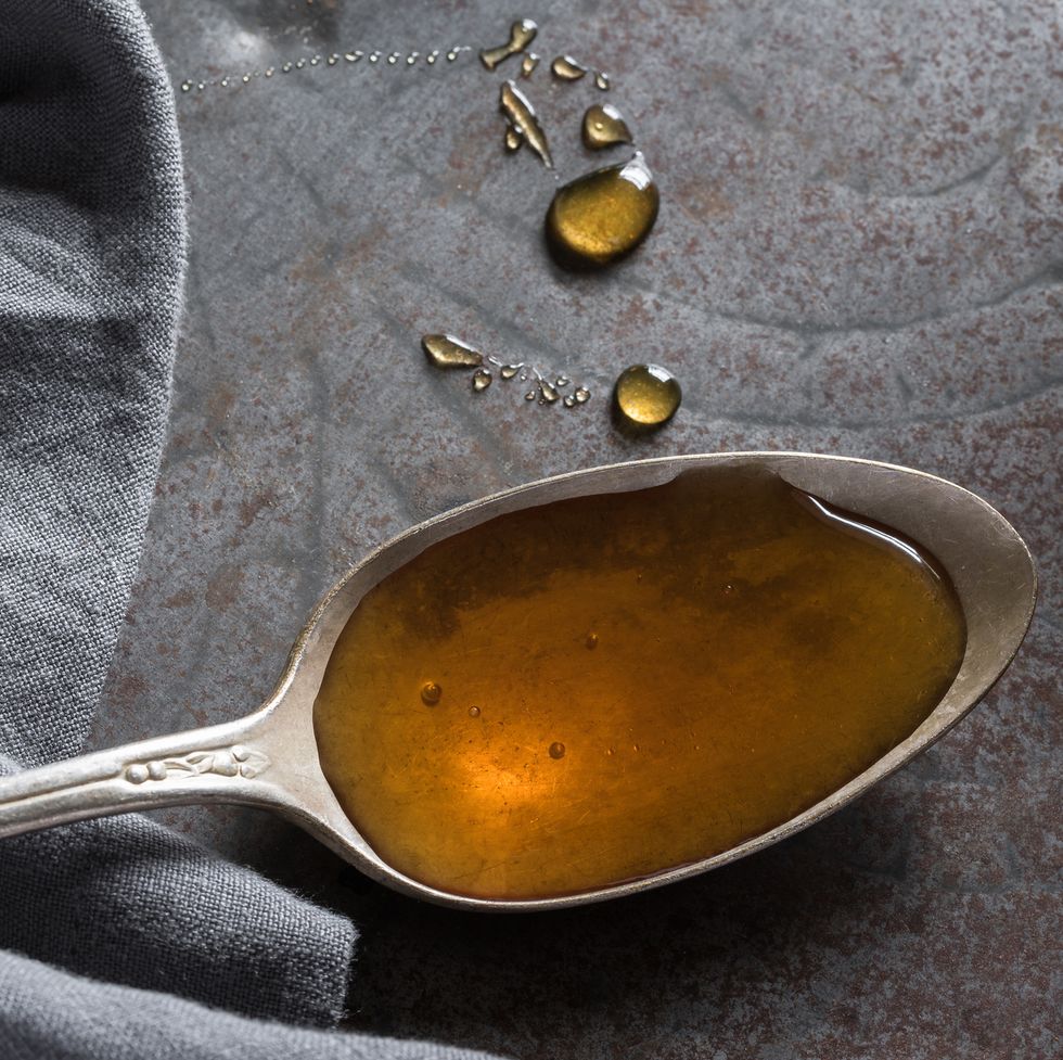 close up of honey in spoon on table