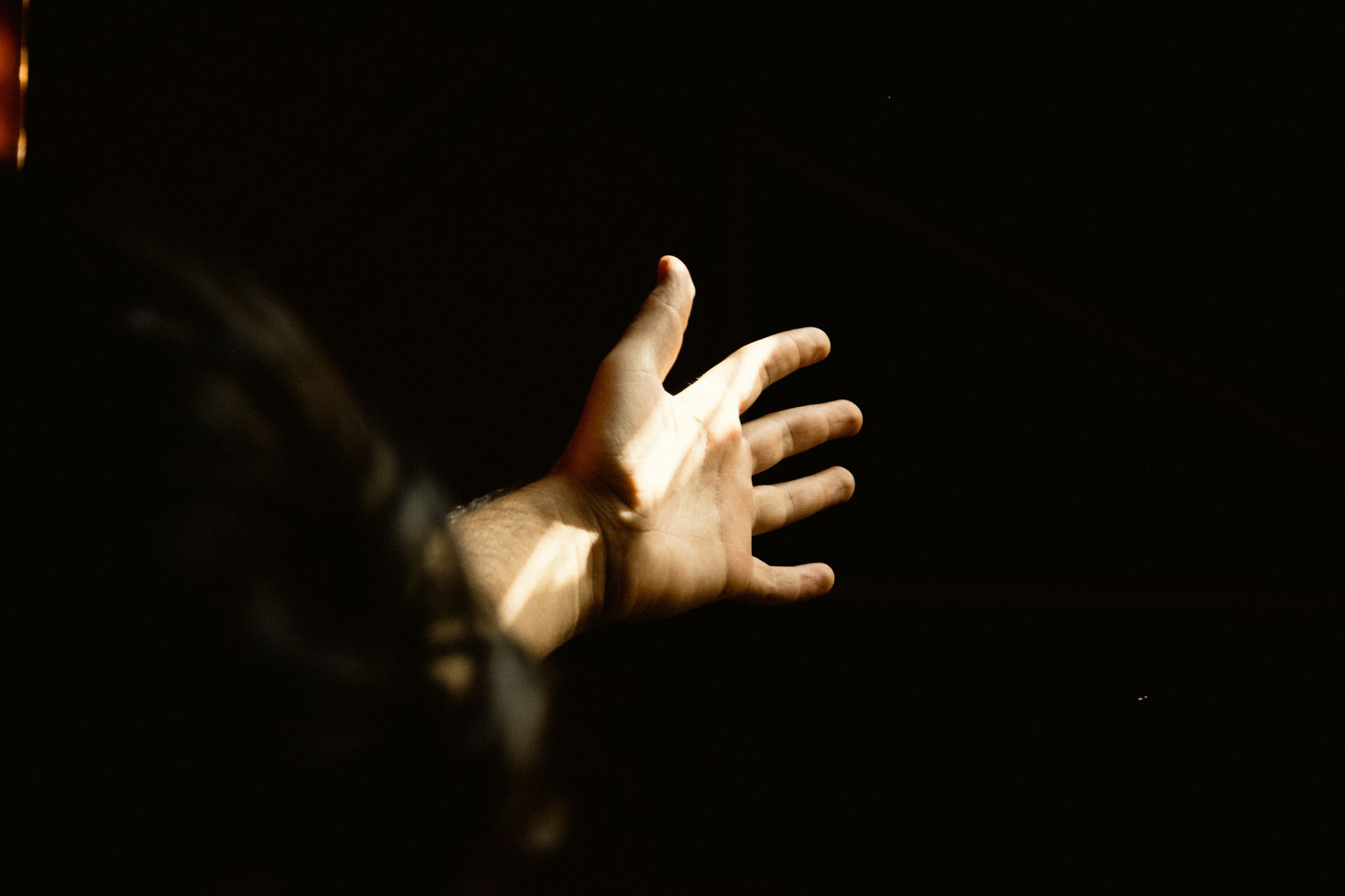 close up of human hand against black background