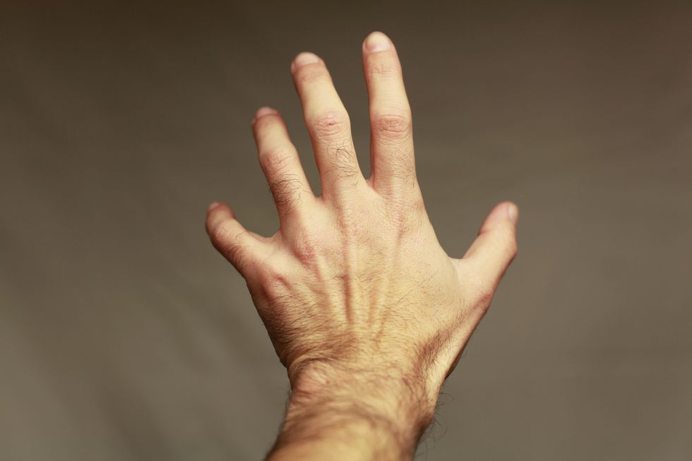 Close-Up Of Human Hand Against Brown Background