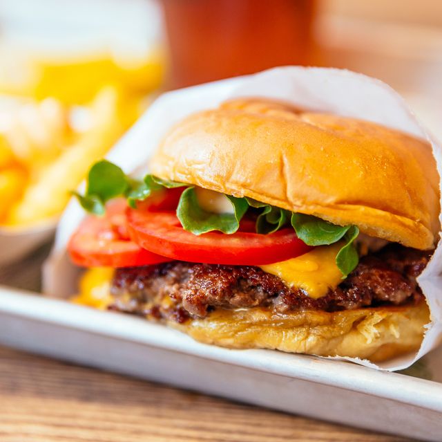 close up of juicy cheeseburger with fresh tomatoes