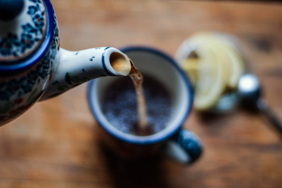 closeup of teapot pouring tea into a cup