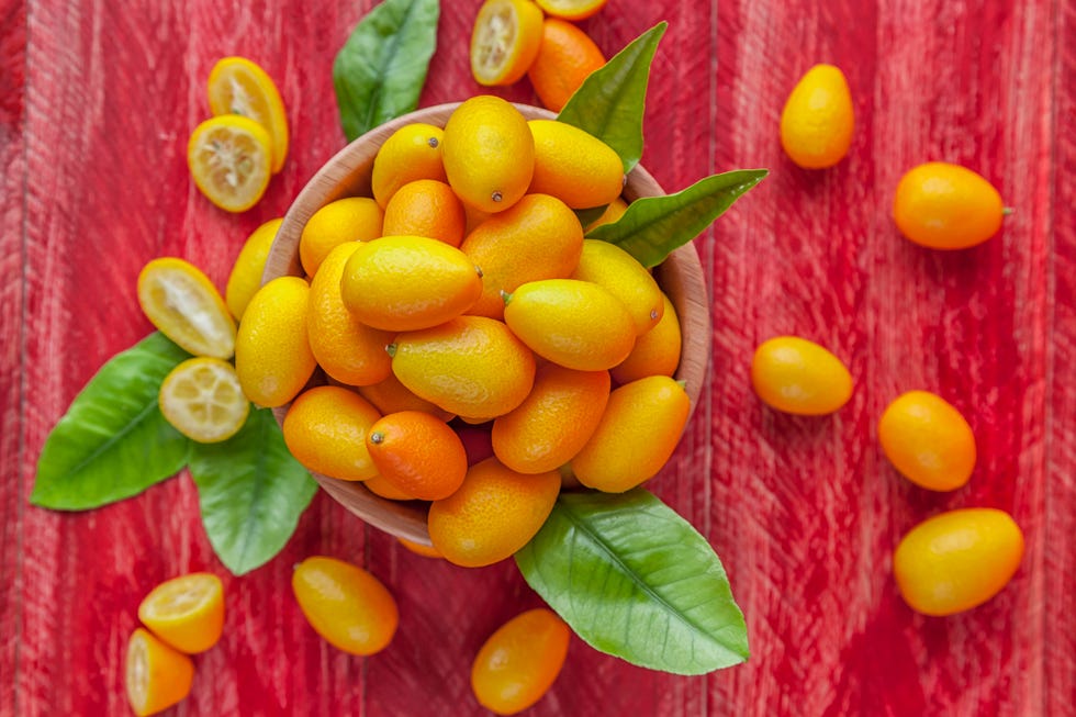 kumquats in bowl on red wooden table