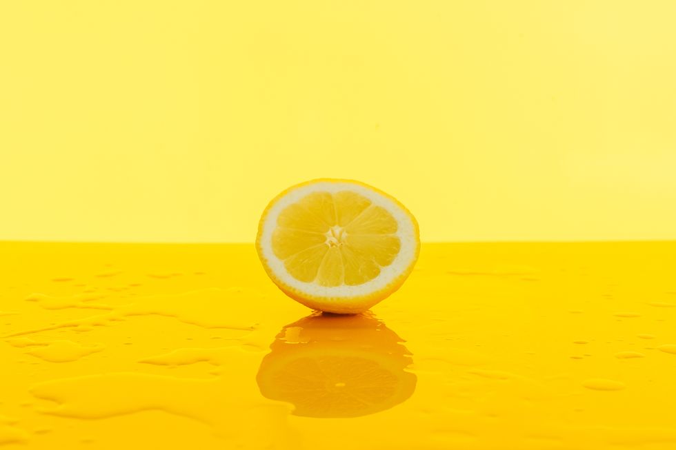 close up of lemon on table against yellow background
