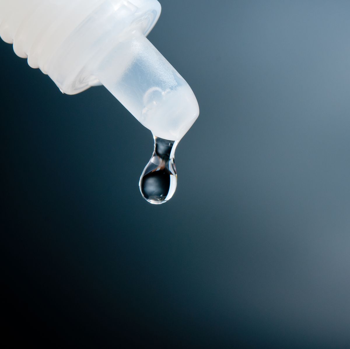 close up of liquid dropping from pipette