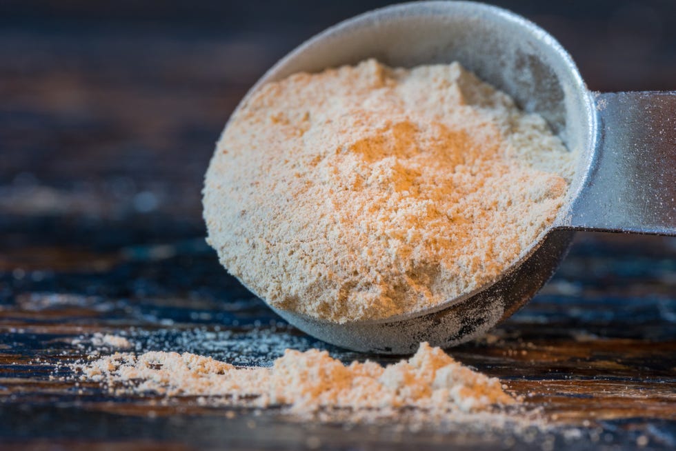 close up of maca powder in spoon on table