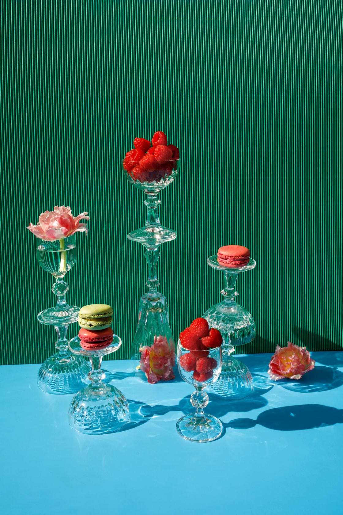 close up of macarons and pink flowers on the green blue background