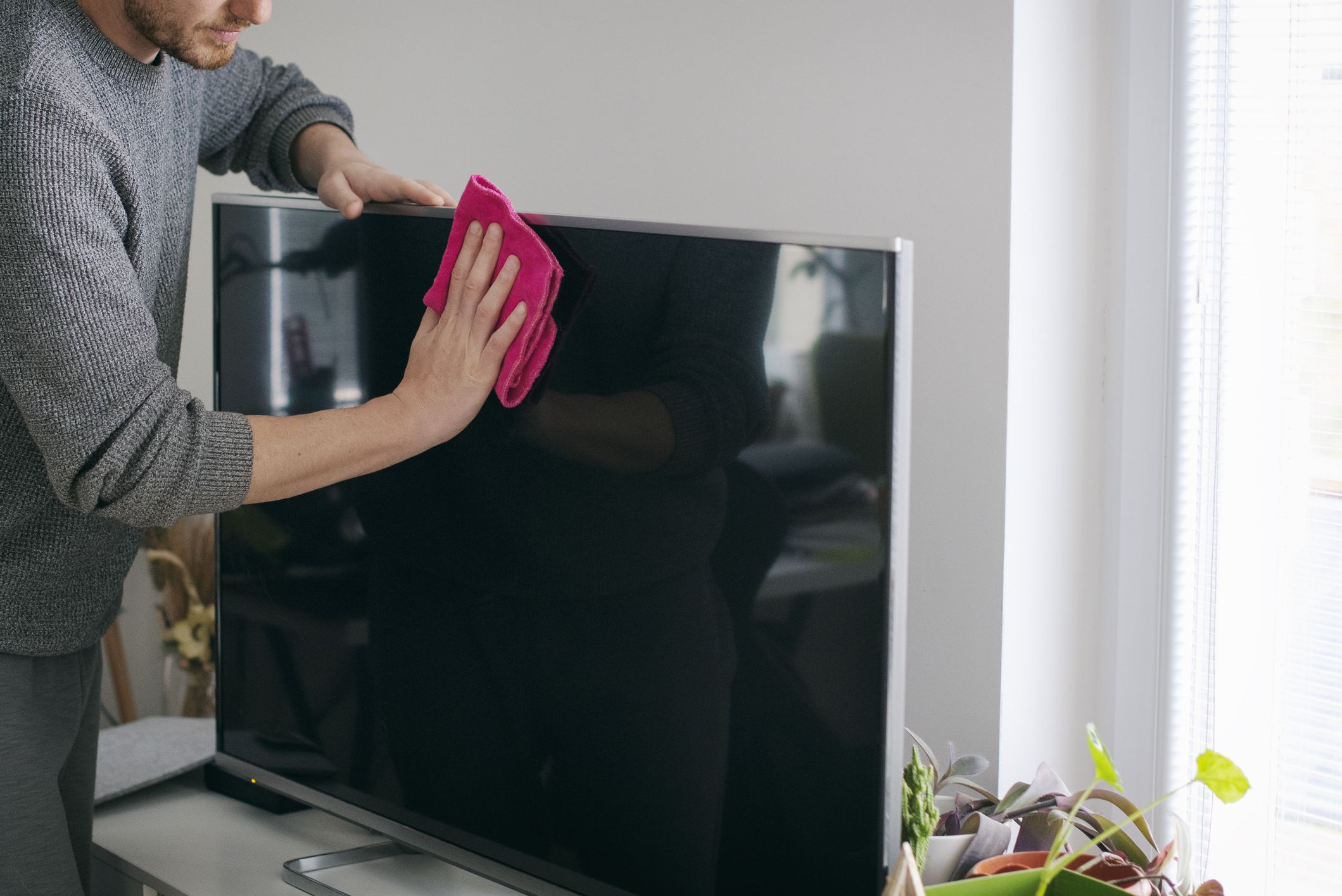 close-up-of-man-cleaning-tv-screen-royalty-free-image-1717686617.jpg