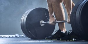 Close-up of man doing deadlift exercise at gym