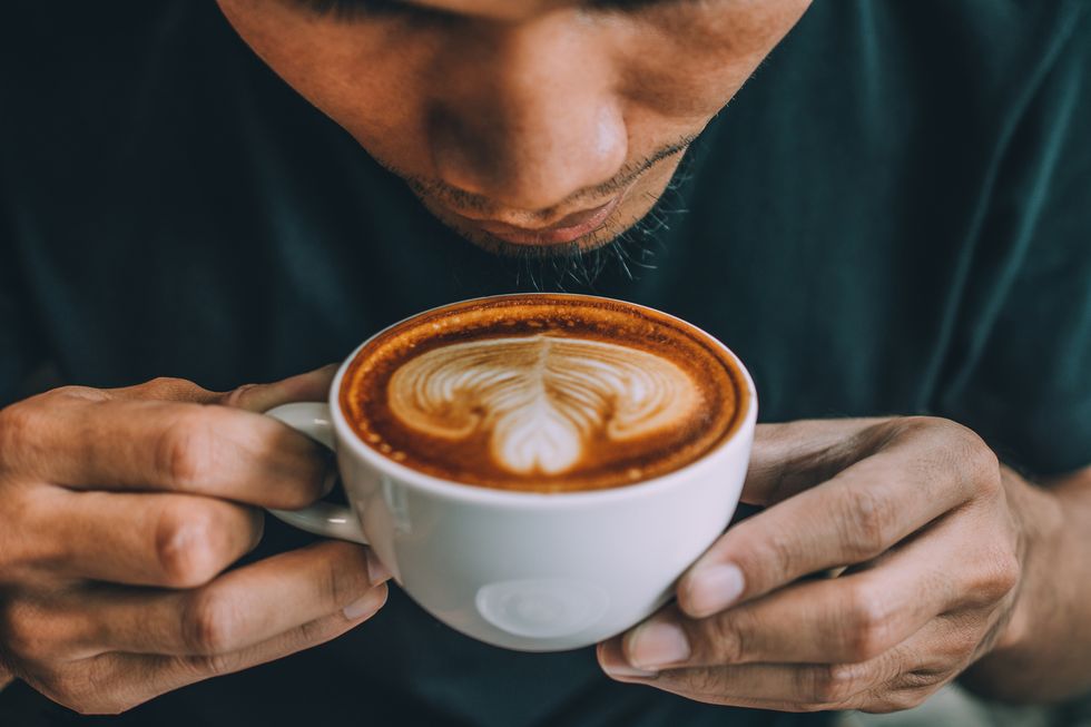 close up of man holding coffee cup