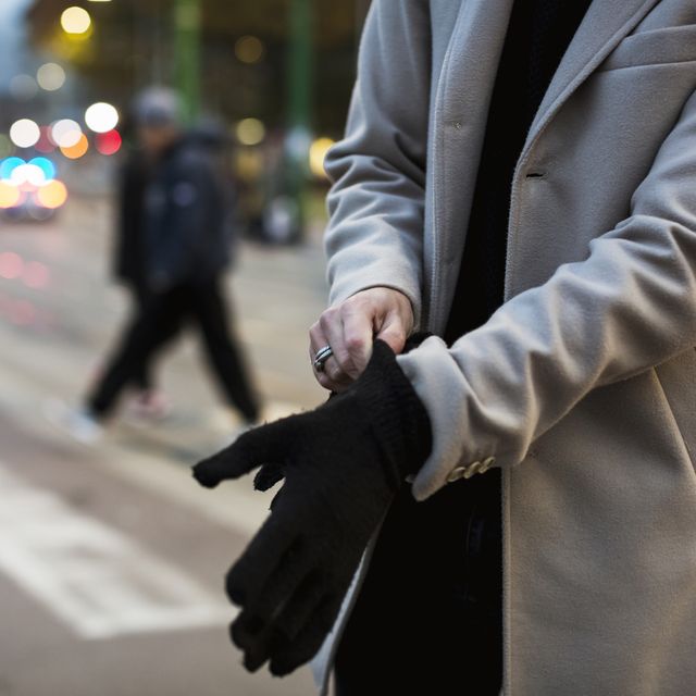 Close-up of man in the city putting on gloves