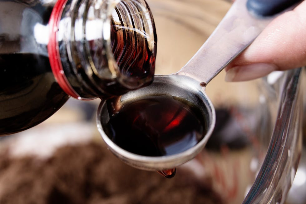close up of medicine being poured onto a teaspoon